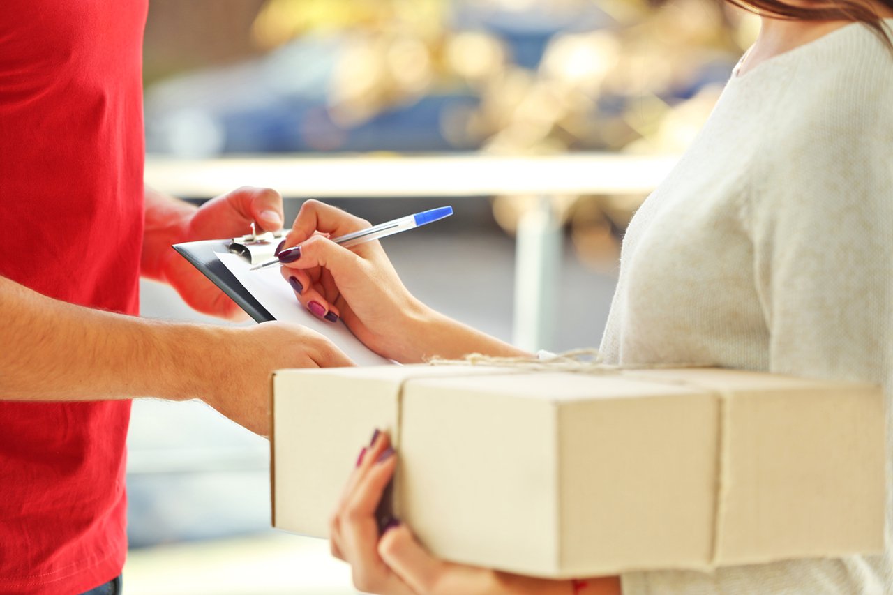 Woman signing receipt of delivery package, close up